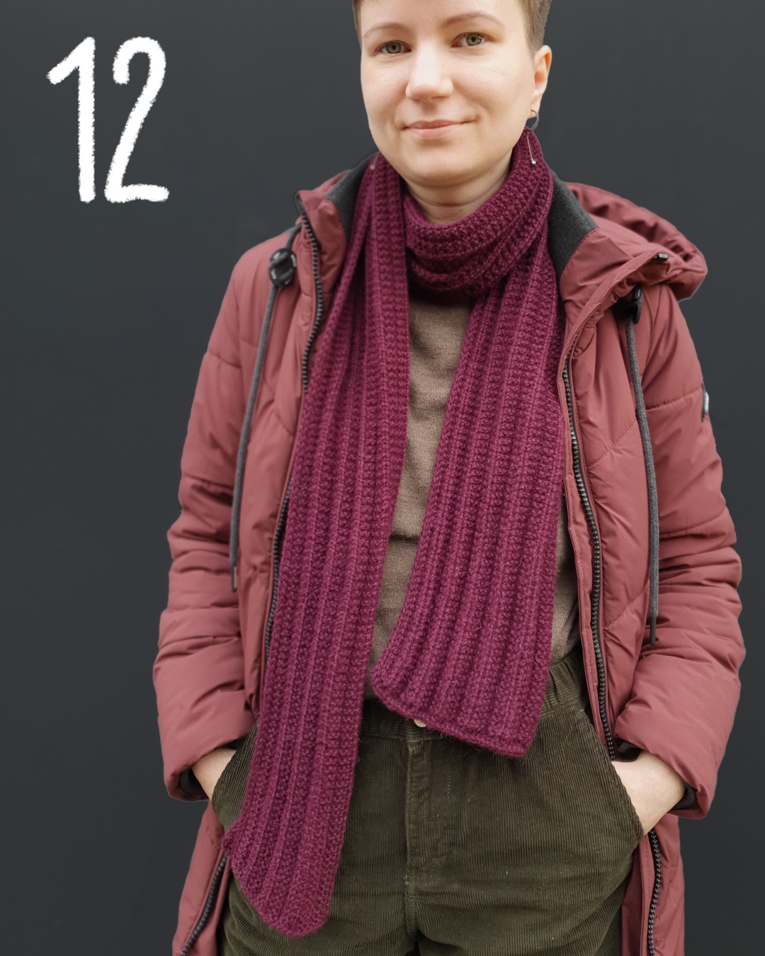 Modell trägt burgunderfarbenen Schal in falschem Patentmuster