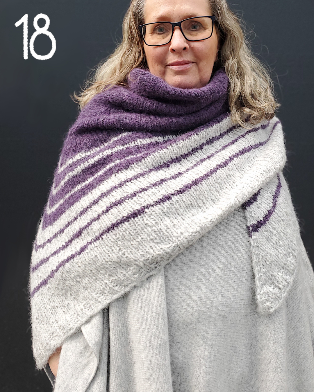 Modell trägt großes violettes Dreieckstuch mit hellgrau gestreiftem Saum