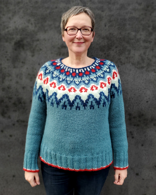 Modell trägt aquafarbenen Rundpassenpullover in Gr. M-L