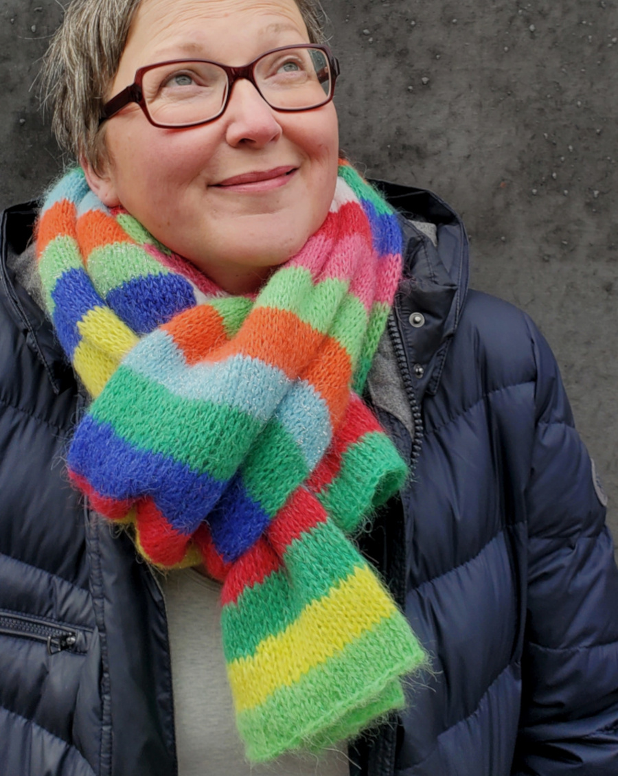 Modell trägt Durchsteckschal in bunten Blockstreifen