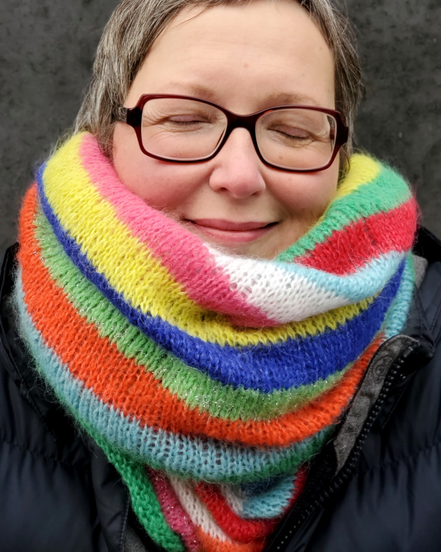 Modell trägt Loop mit bunten Blockstreifen