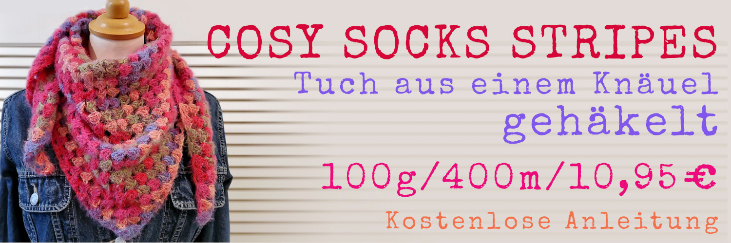 Rot-blau-pinkes Häkeltuch auf Jeansjacke , Schriftzug: Tuch aus einem Knäuel gehäkeltKnäuel