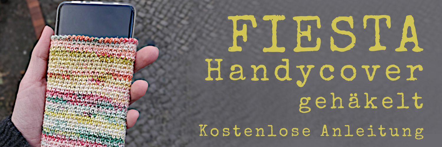 Handy in bunter, gehäkelter Hülle, Schriftzug: Fiesta Handycover gehäkelt, kostenlose Anleitung