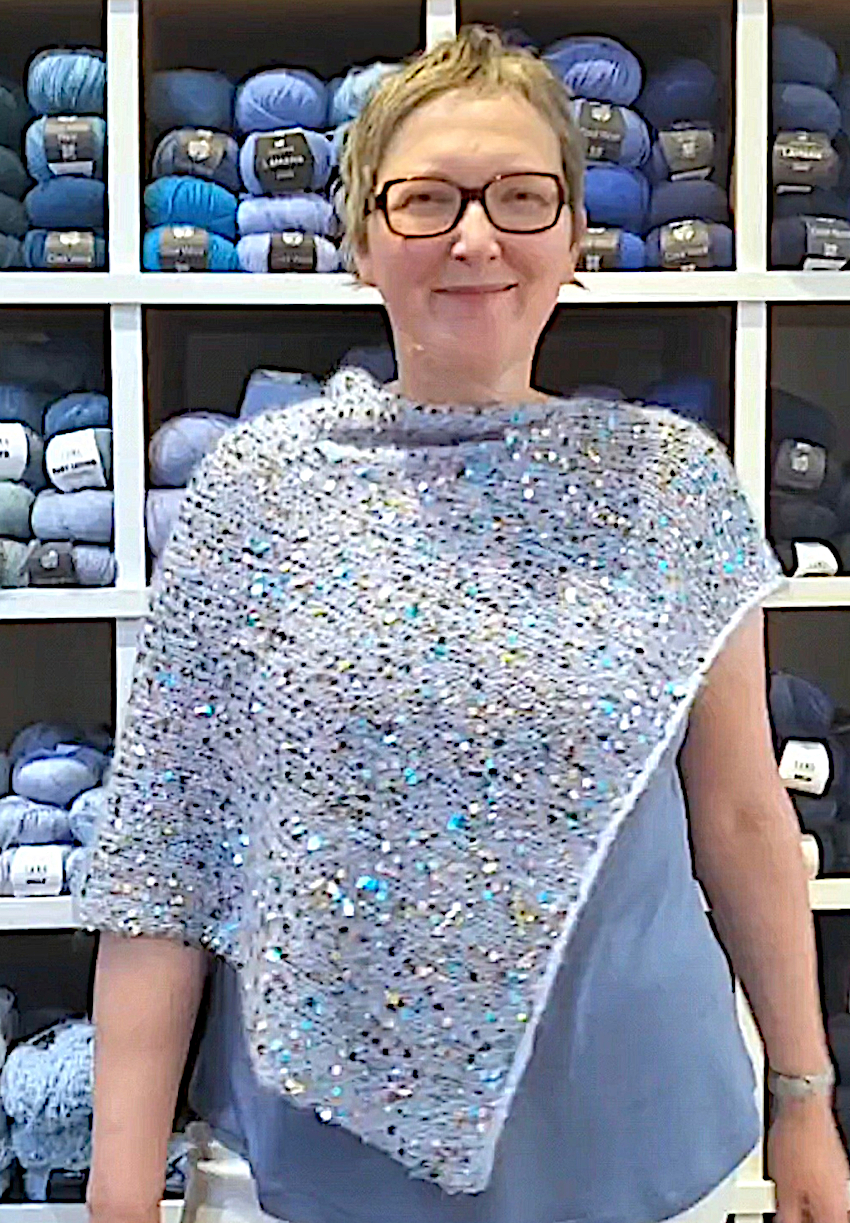 Modell trägt hellblauen Paillettenponcho