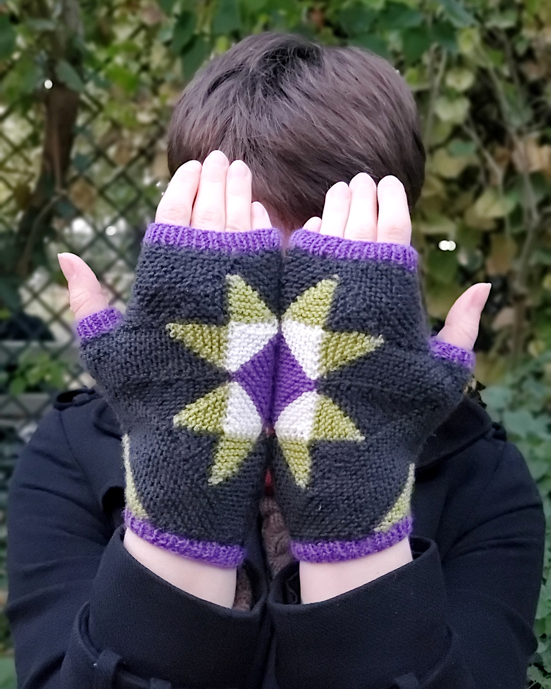 Modell trägt Pulswärmer, hält sie so vors Gesicht, dass sich die zwei halben Sterne auf dem Handrücken zu einem ganzen fügen