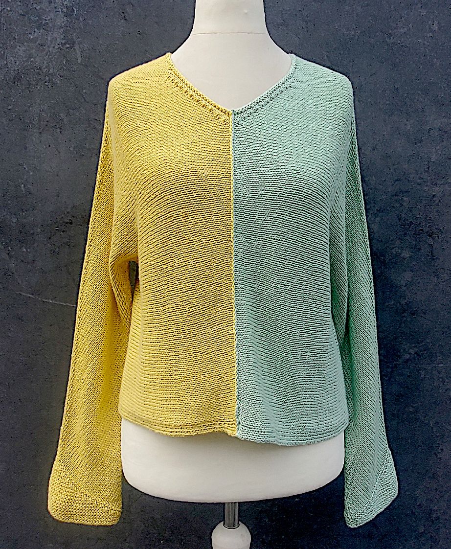 V- Ausschnitt Pullover auf Schneiderpuppe, eine Hälfte gelb, die andere mint