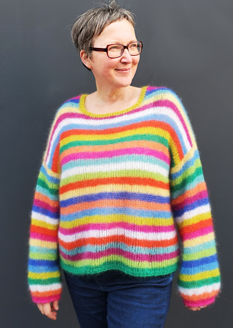 Modell trägt buntgestreifetn Langarmpullover mit Rundhalsausschnitt in 12 Farben