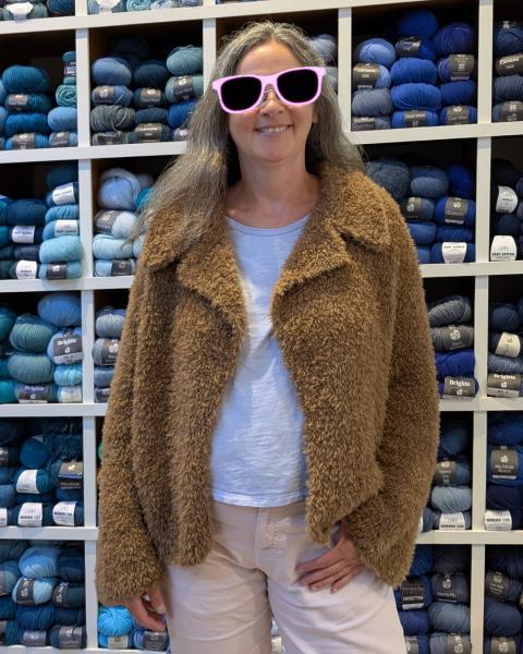 Modell trägt nougatbraune Pelzstrickjacke